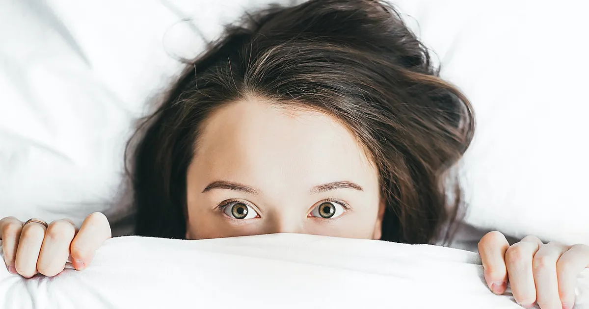 Women peaking from under the cover